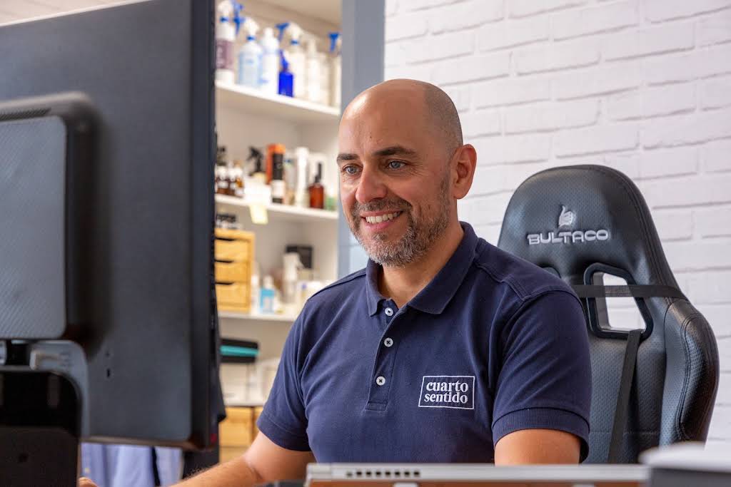 Empleado de nuestra empresa de marketing olfativo, el cual esta trabajando con una sonrisa frente a un ordenador. Estudiando nuevas maneras de satisfacer nuestros trabajadores.